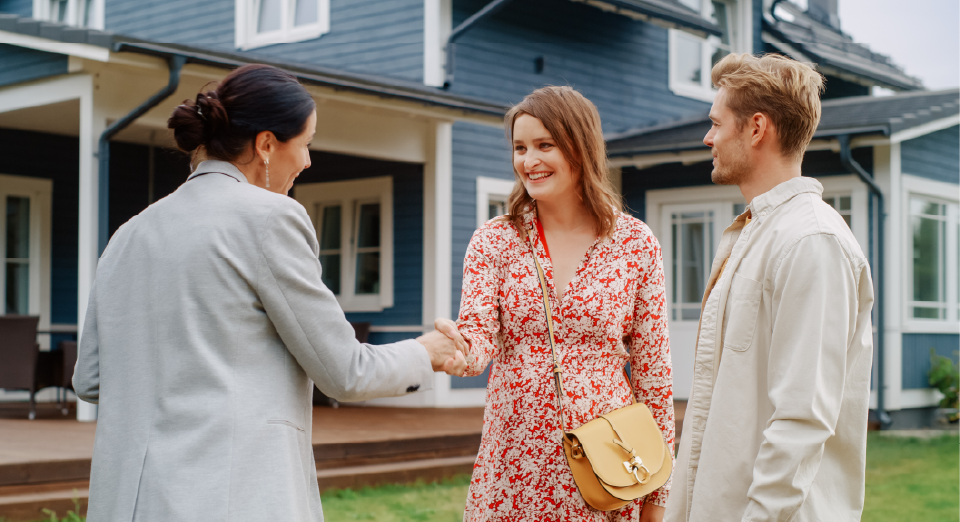 Couple shaking hands with a dealer